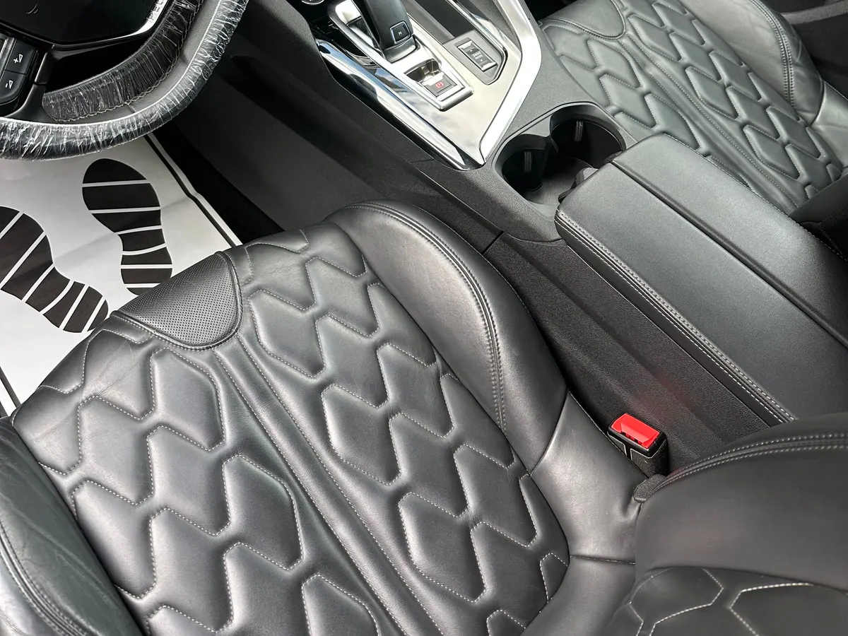Habitacle avant d'une Peugeot 3008 nettoyé, sièges en cuir matelassé et console centrale